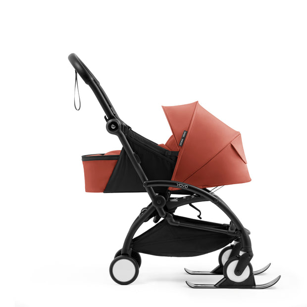 Stokke YOYO skis in black attached to the front wheels of a stroller frame with Newborn Pack in Berry -  Available from Parent Studio