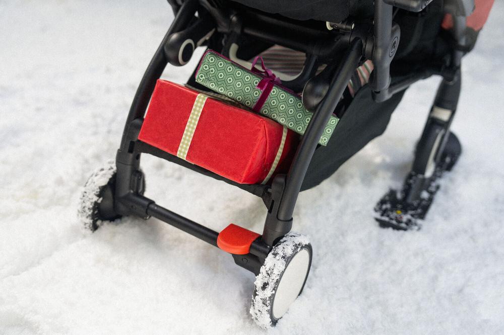 Stokke YOYO stroller gliding smoothly over snow with black skis attached to front wheels - Available from Parent Studio