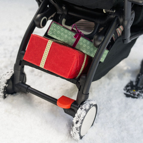Stokke YOYO stroller gliding smoothly over snow with black skis attached to front wheels - Available from Parent Studio