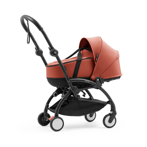 Angle of the Stokke YOYO5 stroller frame featuring the Berry hard-shell bassinet elevated on frame mounting adapters - Available from Parent Studio