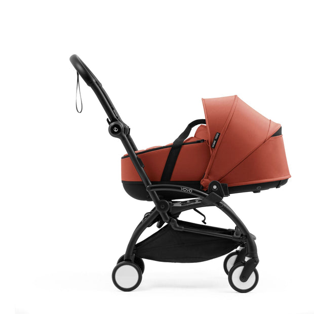 Side view of the Stokke YOYO5 Berry bassinet securely attached to a black stroller chassis using the YOYO bassinet adapters - Available from Parent Studio