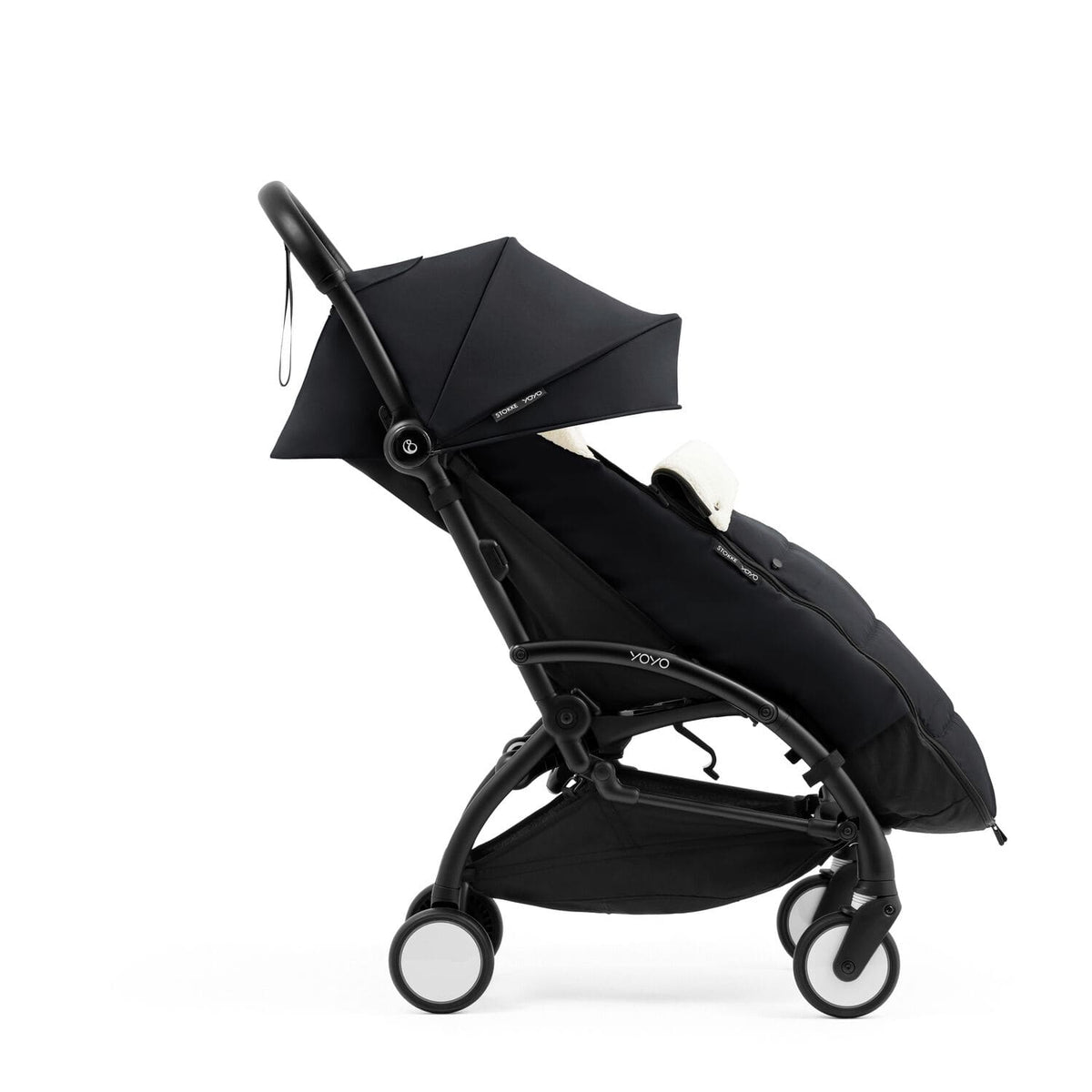 Side profile of the Stokke YOYO5 Stroller and Footmuff in Black with integrated leg rest, available from Parent Studio.