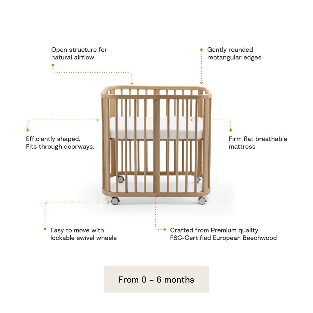 Stokke Nighti mini cot in Natural Beechwood with Stokke accessories including the mattress and wheels set for mobility with features explained — Available from Parent Studio