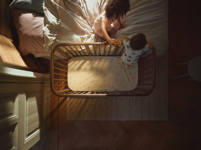 Top-down view of the Stokke Nighti Bed in use as a sibling co-sleeper — Available from Parent Studio