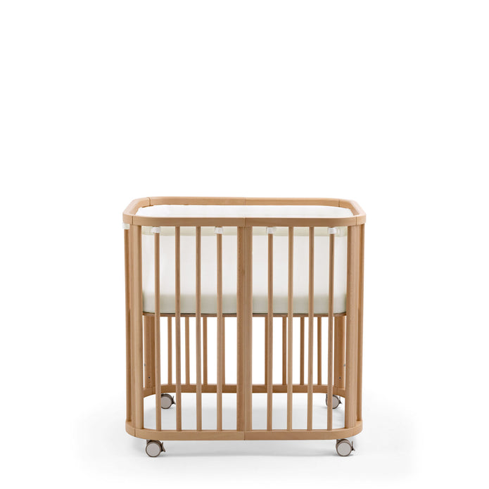 Stokke Nighti Mini Breathable Mesh Liner fitted securely inside a natural wooden newborn crib - Available from Parent Studio London