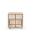 Stokke Nighti Mini Breathable Mesh Liner fitted securely inside a natural wooden newborn crib - Available from Parent Studio London