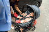 Three-quarter front view of the Stokke YOYO5 chassis transformed into a travel system with a parent-facing Maxi-Cosi car seat - Available from Parent Studio