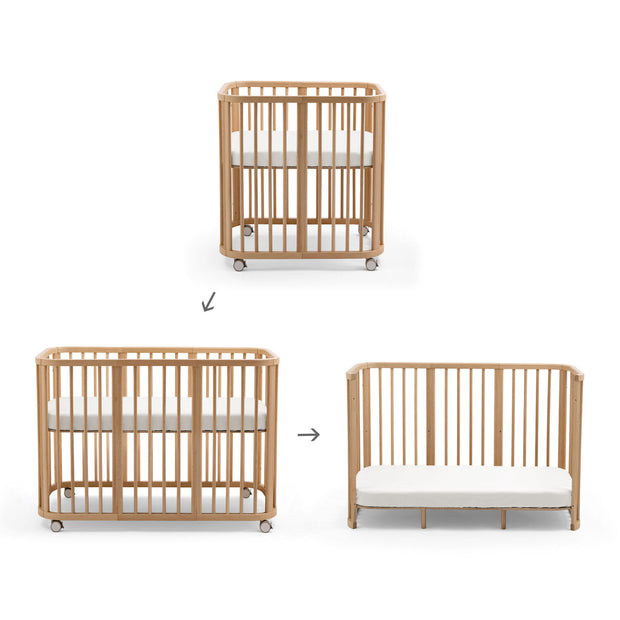 Stokke Nighti mini cot converts into a toddler bed with extension kit in Natural Beech — Available from Parent 