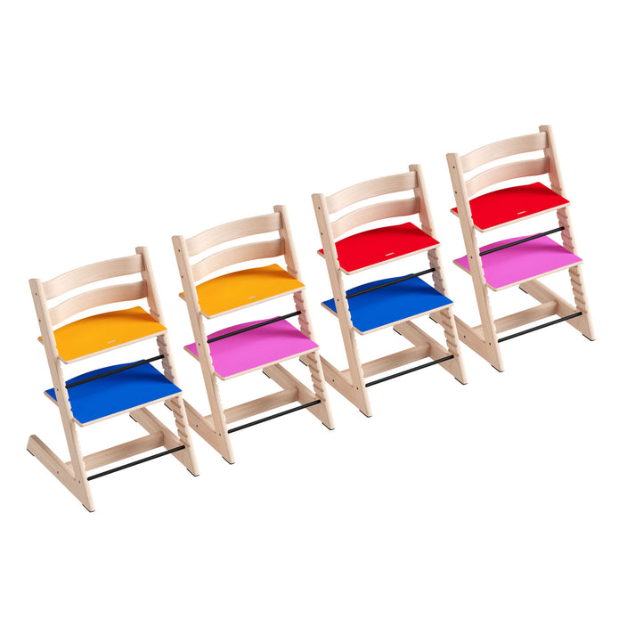 Four profile views of the Stokke Tripp Trapp Chair MoMA Edition showing all combinations of the reversible multi-colour plates and laser-engraved logo, available from Parent Studio.