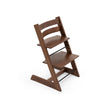 Side profile of the Stokke Tripp Trapp Chair in Signature Walnut showing adjustable seat and footplate, available from Parent Studio.