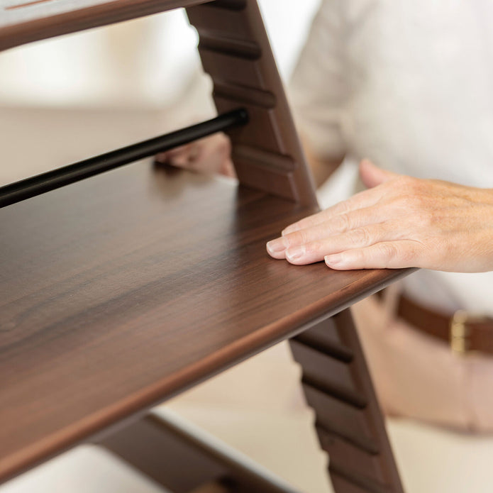  Close-up view of the Stokke Tripp Trapp Chair in Signature Walnut showing grain and smooth touch finish, available from Parent Studio.