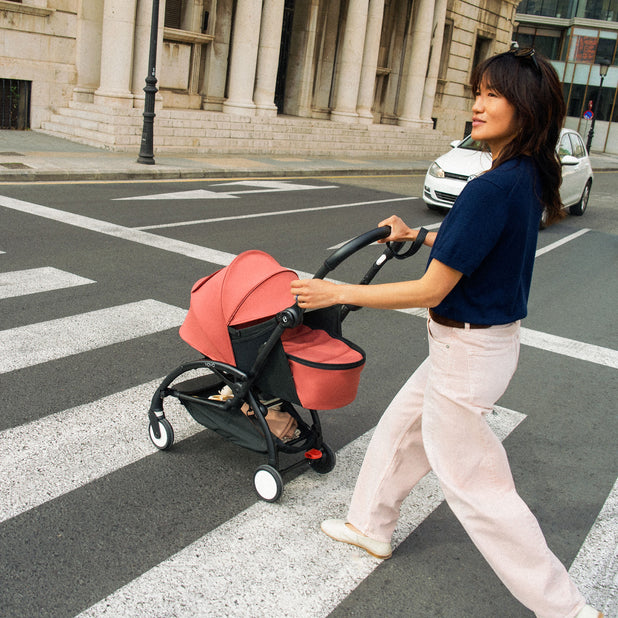 Mom crossing the road in the city with a Stokke YOYO5 newborn stroller